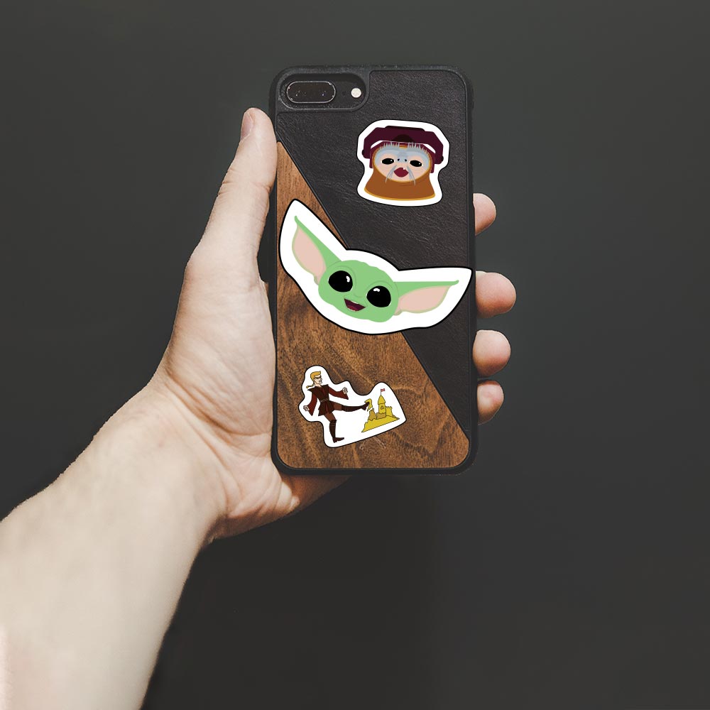 An image of Baby Yoda, Babu Frik, and Anakin kicking a sand castle stickers placed on the back of a phone case.
